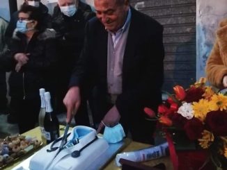 Il dottor Pasquale Gallucci taglia la torta il giorno del suo pensionamento, circondato dai pazienti a Cuturella di Cropani
