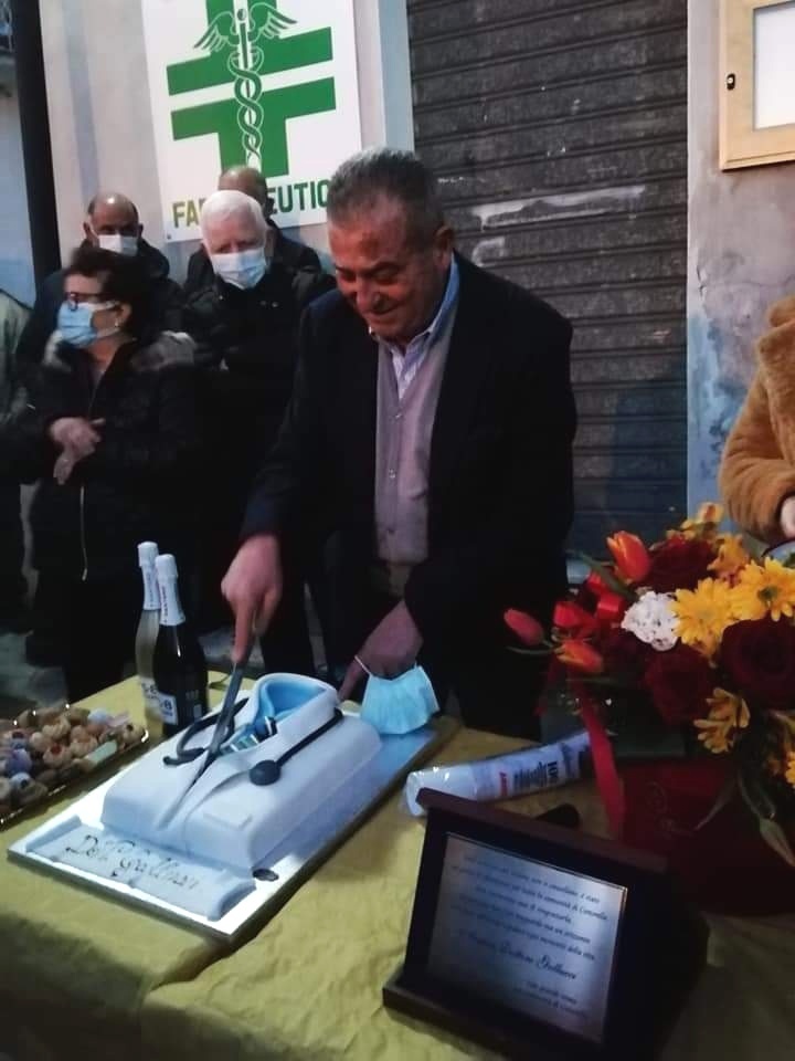 Il dottor Pasquale Gallucci taglia la torta il giorno del suo pensionamento, circondato dai pazienti a Cuturella di Cropani