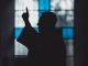 Silhouette di un uomo vicino a una vetrata di chiesa, luce calma