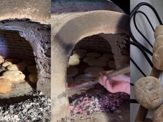 Forno a cupola in mattone refrattario con fuoco acceso, targa FORNO COMUNALE visibile