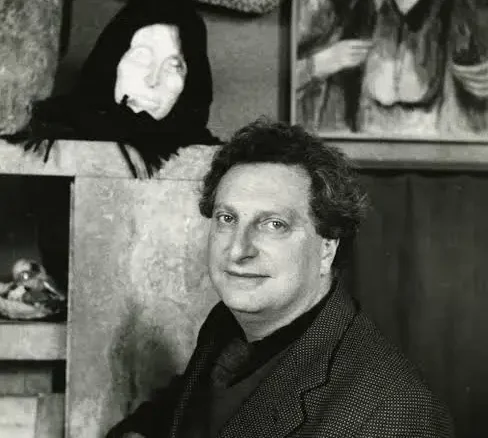 Carlo Levi in posa davanti a una scultura di testa femminile e a un dipinto con figure anziane