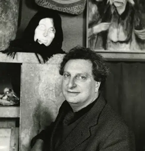 Carlo Levi in posa davanti a una scultura di testa femminile e a un dipinto con figure anziane
